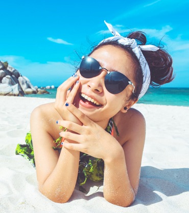 a girl lying on the sand and smiling